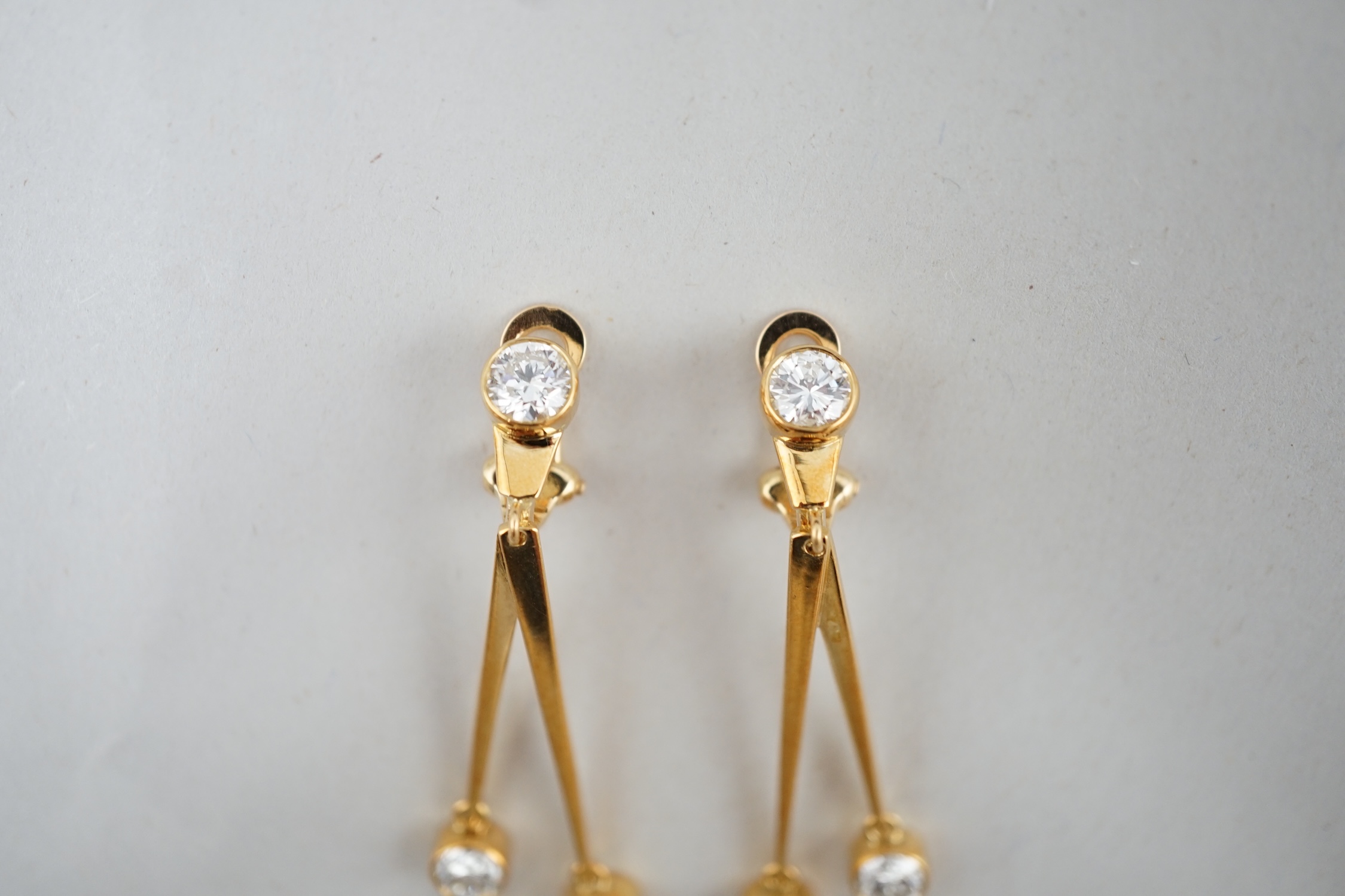 A pair of modern 18ct gold and three stone diamond set double drop ear clips